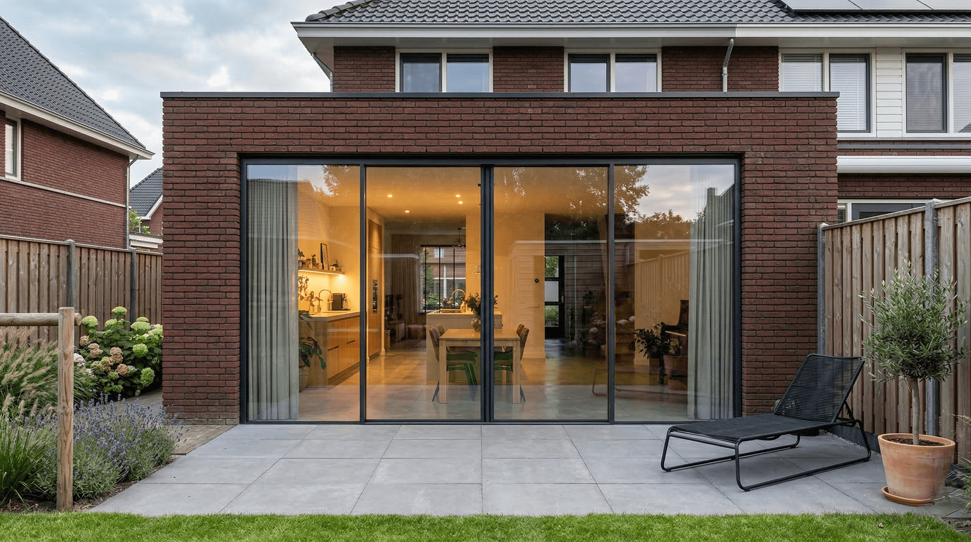 3-delige antraciet aluminium schuifpui in vrijstaande woning bij avondlicht — levensduur en duurzaamheid